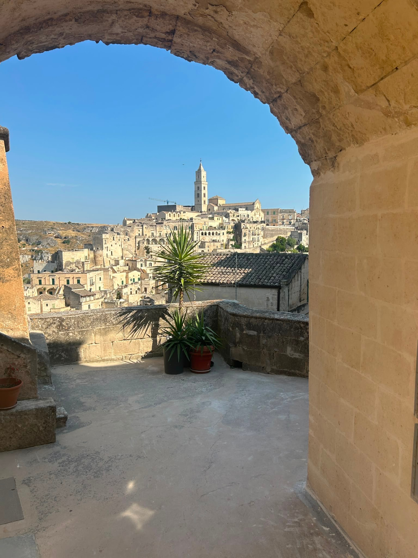 Blick durch einen Steinbogen auf die Altstadt von Matera